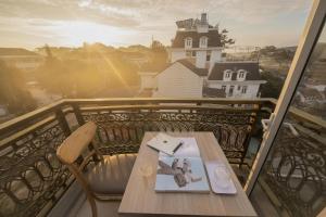 a table on a balcony with a view of a building at Bee Luxury Dalat Hotel in Da Lat