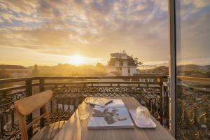 a table on a balcony with a view of a lighthouse at Bee Luxury Dalat Hotel in Da Lat