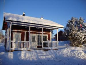 a house with a porch in the snow at Purolomat in Merikarvia
