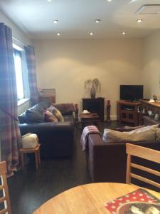 a living room with two couches and a television at Ringinglow cottage in Sheffield