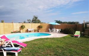 a backyard with a pool with chairs and an umbrella at Le Poirier Perfect for 2 adults and 2 children Heated Pool and Games Room in Auverse