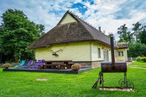 a yellow house with purple chairs and a table at Uuelu turismitalu in Kõrkküla