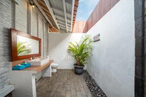 a bathroom with a sink and a toilet at Bukit Taman Cottages in Nusa Lembongan +93 photos