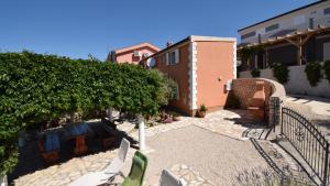a patio with chairs and trees and a building at Coastal Retreat Villa Milena by Villas Guide in Novalja