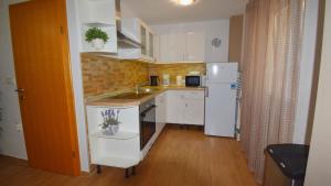 a small kitchen with a sink and a refrigerator at Coastal Retreat Villa Milena by Villas Guide in Novalja +11 photos