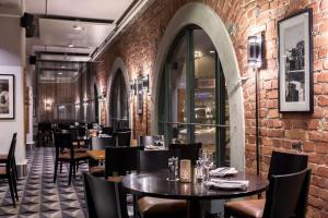 a restaurant with tables and chairs and a brick wall at Scandic Grand Marina in Helsinki