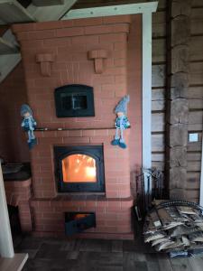 a brick fireplace with two figurines on top of it at Užmiesčio trobelė in Mackėnai