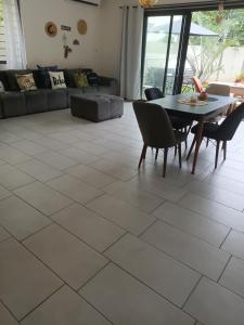 a living room with a table and chairs at Mira lune guesthouse in Flic-en-Flac