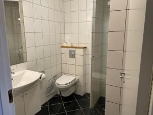 a bathroom with a toilet and a sink at Hotel Aarhus City Apartments in Aarhus +57 photos