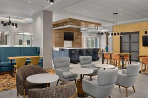a waiting room with tables and chairs and a kitchen at Hampton Inn By Hilton Dexter in Dexter