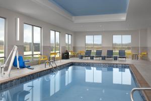 a pool in a hotel room with chairs and tables at Hampton Inn By Hilton Dexter in Dexter