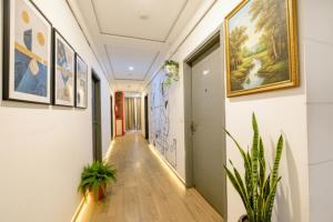 a hallway with paintings on the walls and plants at FabHotel Dev Palace I - Pitampura in New Delhi