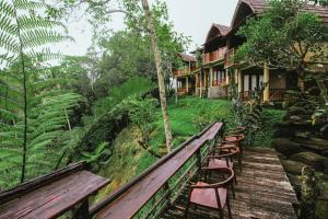a wooden bench in front of a house at Four Mountains Villa Bedugul by AGATA in Bedugul