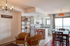 a kitchen and dining room with a table and chairs at Sea You Apartamentos Valencia Port Saplaya in Port Saplaya