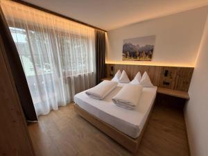 a bedroom with a bed with white sheets and pillows at Appartements Michael in Sesto