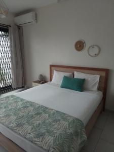 a bedroom with a large white bed with blue pillows at Mira lune guesthouse in Flic-en-Flac +4 photos
