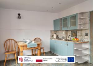 a kitchen with blue cabinets and a table and chairs at Vincent OldTown Apartments in Wrocław