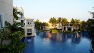 a view of a pool of water with buildings and palm trees at Hua Hin Blue Lagoon in Cha Am