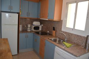 a kitchen with blue cabinets and a sink and a refrigerator at Villa Cristal II 3308 - Resort Choice in Los Nietos