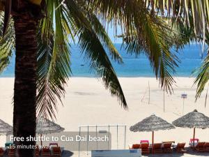 a beach with chairs and umbrellas and the ocean at NA Hoian Hotel in Hoi An