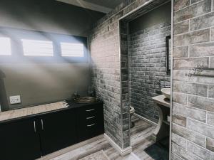 a bathroom with a sink and a brick wall at Dolphin View Accomodation in Strandfontein +28 photos