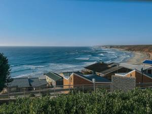 a view of a beach with houses and the ocean at Dolphin View Accomodation in Strandfontein