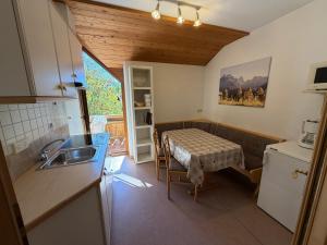 a kitchen with a table and a sink in a room at Appartements Michael in Sesto +32 photos