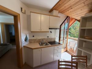 a kitchen with white cabinets and a sink in a room at Appartements Michael in Sesto