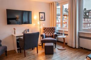 a living room with a chair and a table and a tv at Bartmanns Haus & Schwan GmbH in Dillenburg