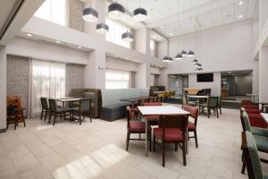 a dining room with tables and chairs and a tv at Hampton Inn & Suites McAllen in McAllen