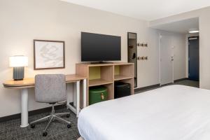 a hotel room with a bed and a desk and a television at Spark by Hilton Murfreesboro in Murfreesboro