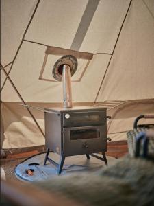 a stove sitting in a tent with at Tomnauld Farm in Pitlochry