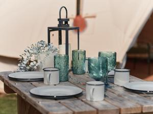 a wooden table with plates and candles on it at Tomnauld Farm in Pitlochry