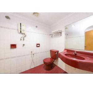 a bathroom with a red toilet and a sink at Super OYO 473 Comfort Hotel 2 in Klang