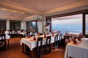 a man standing at a table in a restaurant at Dhulikhel Lodge Resort in Dhulikhel