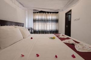 a bedroom with a bed with red flowers on it at Villa Sanitha in Ambalangoda