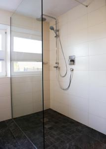 a shower with a glass door in a bathroom at Ferienwohnung Köchl in Münster