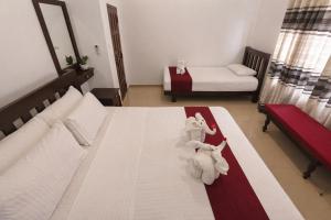 a bedroom with a bed with towels on it at Villa Sanitha in Ambalangoda
