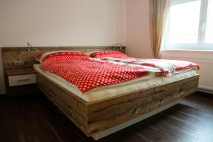 1 dormitorio con cama de madera y almohadas rojas y blancas en Ferienwohnung Köchl, en Münster