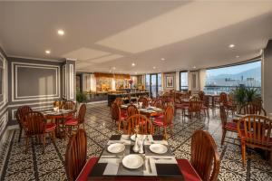 a restaurant with tables and chairs and a large window at Hotel Del Luna Boutique in Danang
