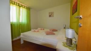 a bedroom with a bed with a green curtain at Coastal Retreat Villa Milena by Villas Guide in Novalja