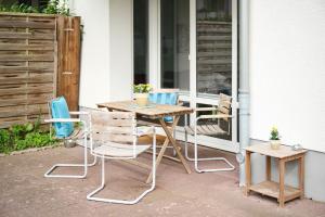 a wooden table and chairs on a patio at Ferienwohnung Hafeneck Moba-Travel in Lübeck