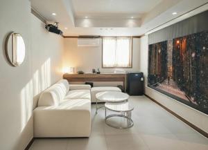 a living room with a white couch and a table at Glen Stay Dongducheon in Tongduch'ŏn