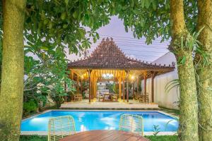 a swimming pool with a gazebo next to a house at Villa Omah Rindu in Yogyakarta