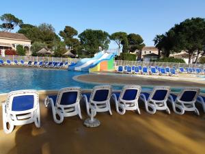 a row of chairs and a water slide at a pool at Maison blanche in Calvisson