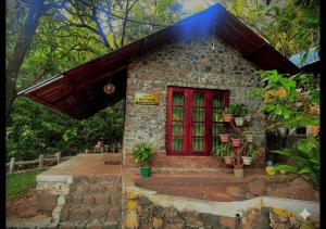 a small stone house with a red door at Sandungira Eco Resort in Belihuloya +21 photos