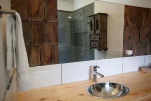 a bathroom sink with a wooden counter and a mirror at Mareas Ralun Lodge in Ralún +102 photos
