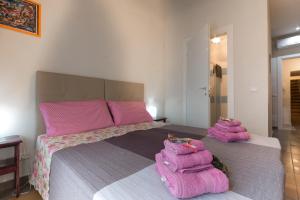 een slaapkamer met een groot bed met roze kussens erop bij Antico Mercato in Ragusa