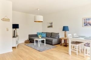 a living room with a couch and a table at Ferienwohnung Sonnendeck Moba-Travel in Priwall +11 photos