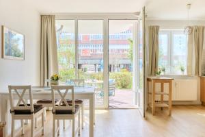 a kitchen and dining room with a table and chairs at Ferienwohnung Sonnendeck Moba-Travel in Priwall